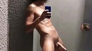 Curly young man wanks in front of the mirror